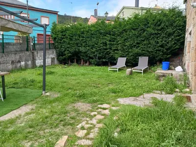 two chairs sitting in the grass in a yard at Piedad Fernández Fernández Gestión de Inmuebles IV in Burela de Cabo