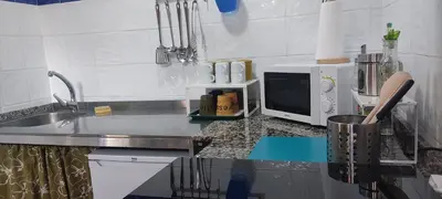 a kitchen with a sink and a microwave on a counter at WITERICUS hospedaxe in Guitiriz