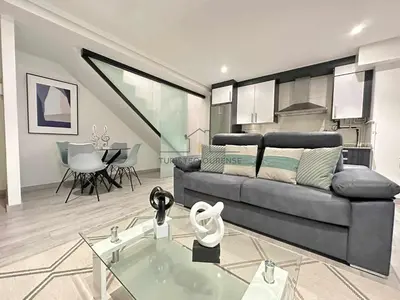 a living room with a couch and a table at A morada das Camelias in Ourense