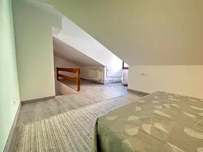 a bedroom with a bed and a staircase in a room at A morada das Camelias in Ourense