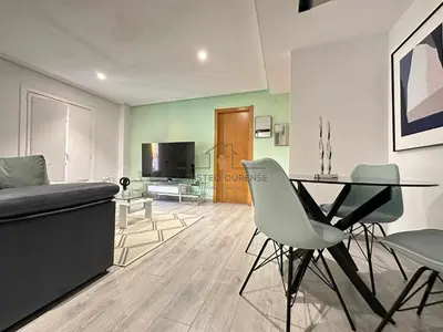 a living room with a table and chairs and a couch at A morada das Camelias in Ourense