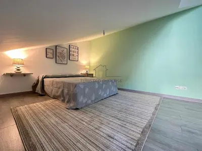 a bedroom with a large bed and a rug at A morada das Camelias in Ourense