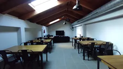 a room with tables and chairs and a couch at Albergue de Cerceda in Cerceda