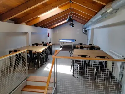 a dining room with tables and chairs and wooden ceilings at Albergue de Cerceda in Cerceda
