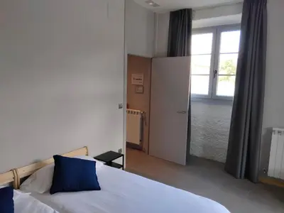 a bedroom with a large bed with blue pillows at Albergue de Cerceda in Cerceda