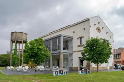 a large white building with a water tower at Albergue de Cerceda in Cerceda