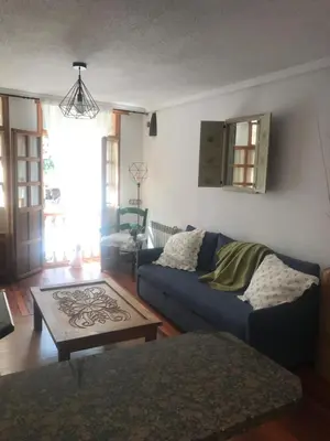 a living room with a blue couch and a coffee table at La Casina de Somiedo in Pola de Somiedo