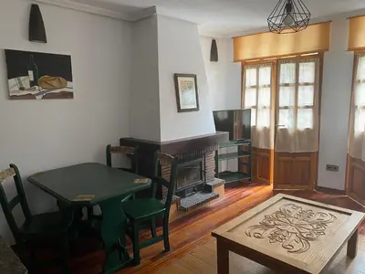 a living room with a table and a fireplace at La Casina de Somiedo in Pola de Somiedo