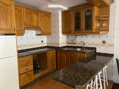 a kitchen with wooden cabinets and a sink at La Casina de Somiedo in Pola de Somiedo