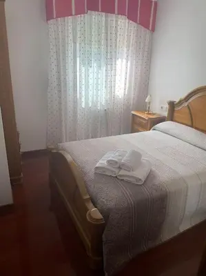 a bedroom with a bed with two towels on it at O Lar de Jose in Monforte de Lemos