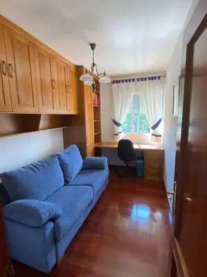 a living room with a blue couch and a desk at O Lar de Jose in Monforte de Lemos