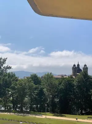a view of a park with trees and a building at O Lar de Jose in Monforte de Lemos