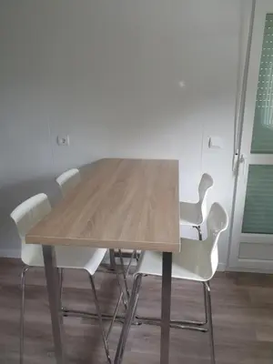 a wooden table and white chairs in a room at VUT Sierra Pambley in Villablino