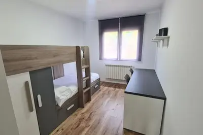 a small room with a bunk bed and a desk at VUT Sierra Pambley in Villablino