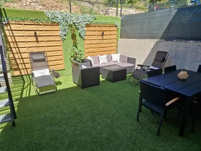 a patio with a table and chairs on grass at VUT Sierra Pambley in Villablino