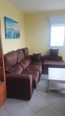 a living room with a large brown leather couch at Grecia in Barreiros