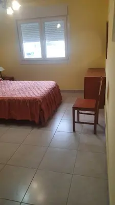 a bedroom with a bed and a chair and a window at Grecia in Barreiros