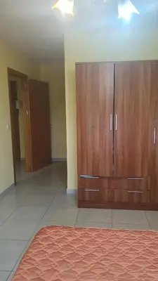 a large room with wooden cabinets and a rug at Grecia in Barreiros