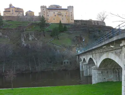 a bridge over a river with a castle in the background at Hotel Las Treixas in Puebla de Sanabria