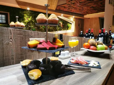 a table with three tiers of food and drinks and wine at Hotel Las Treixas in Puebla de Sanabria