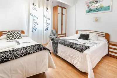 two beds sitting next to each other in a bedroom at Hostal 