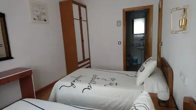 a bedroom with two beds with writing on the sheets at Hostal 