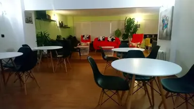 a room with tables and chairs and a couch at Hostal 