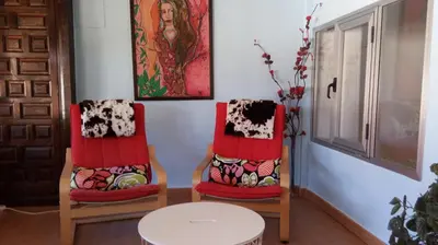 two chairs with red cushions sitting next to a table at Hostal 