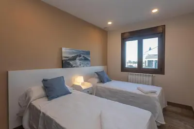 a room with two beds and a window at Hacienda El Esteiro - Villas vacacionales in Tapia de Casariego