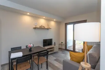 a living room with a table and a couch and a television at Hacienda El Esteiro - Villas vacacionales in Tapia de Casariego