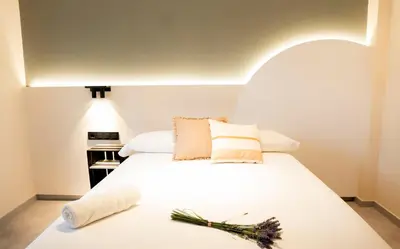 a bedroom with a large white bed with flowers on it at Coliving Compostela in Santiago de Compostela
