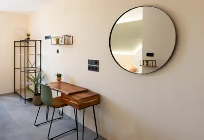 a mirror on a wall with a table and chairs at Coliving Compostela in Santiago de Compostela