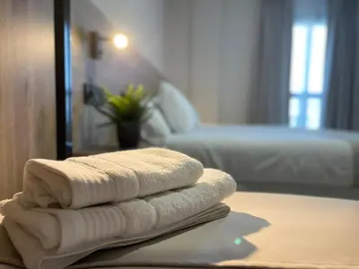 a pile of towels sitting on a table in a room at URBAN Pensión in Melide