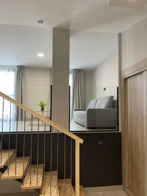 a living room with a bed and a staircase at URBAN Pensión in Melide