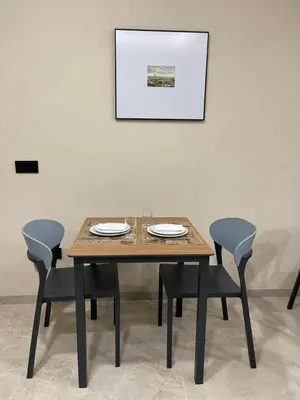 a wooden table with chairs and a picture on the wall at URBAN Pensión in Melide