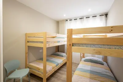 two bunk beds in a small room with a chair at Miño Suites I in Miño
