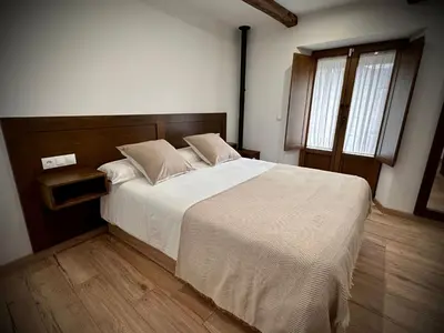 a bedroom with a large bed and a window at La Casina de la Yeye San Cristóbal de Valdueza in San Cristóbal de Valdueza