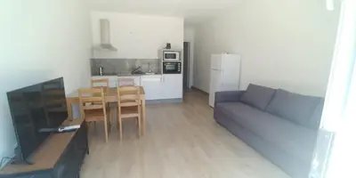 a living room with a couch and a table and a kitchen at Apartamentos Turísticos Magencio in Carucedo