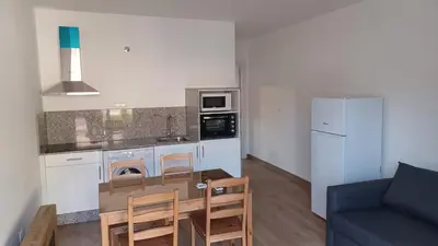 a kitchen with a table and chairs in a room at Apartamentos Turísticos Magencio in Carucedo