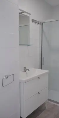 a white bathroom with a sink and a mirror at Apartamentos Turísticos Magencio in Carucedo