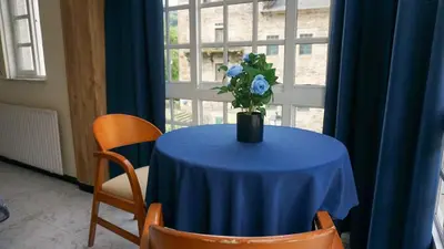 a blue table with a vase with a blue flower on it at Pensión Castro Parrillada in Samos