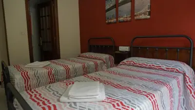 two beds sitting next to each other in a room at Pensión Castro Parrillada in Samos