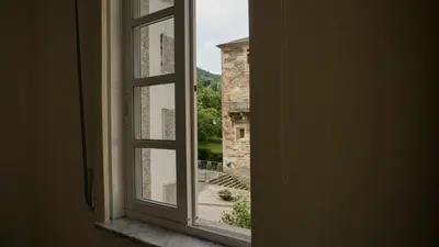 an open window with a view of a building at Pensión Castro Parrillada in Samos