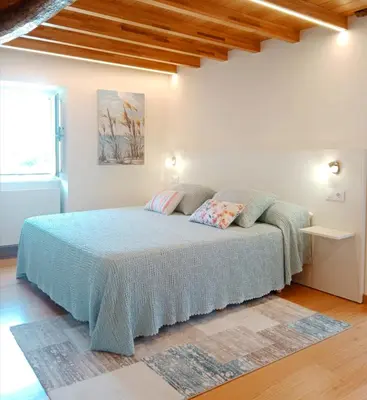 a bedroom with a bed with a blue blanket at Casa Lolita 1 in Viveiro