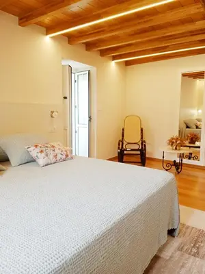a bedroom with a white bed and a chair at Casa Lolita 1 in Viveiro