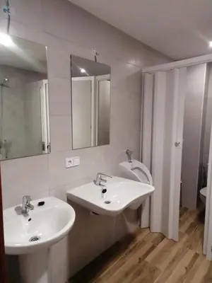 a bathroom with two sinks and a mirror at Albergue El Templarin in Ponferrada