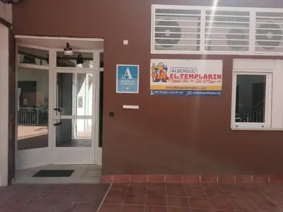 a door to a building with a sign on it at Albergue El Templarin in Ponferrada