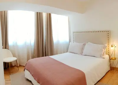 a bedroom with a large bed with white sheets and pillows at Ribeira in Vivero