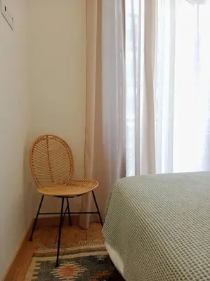a chair sitting next to a bed next to a window at Ribeira in Vivero