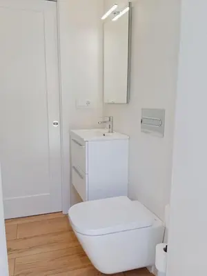 a white bathroom with a toilet and a sink at Ribeira in Vivero